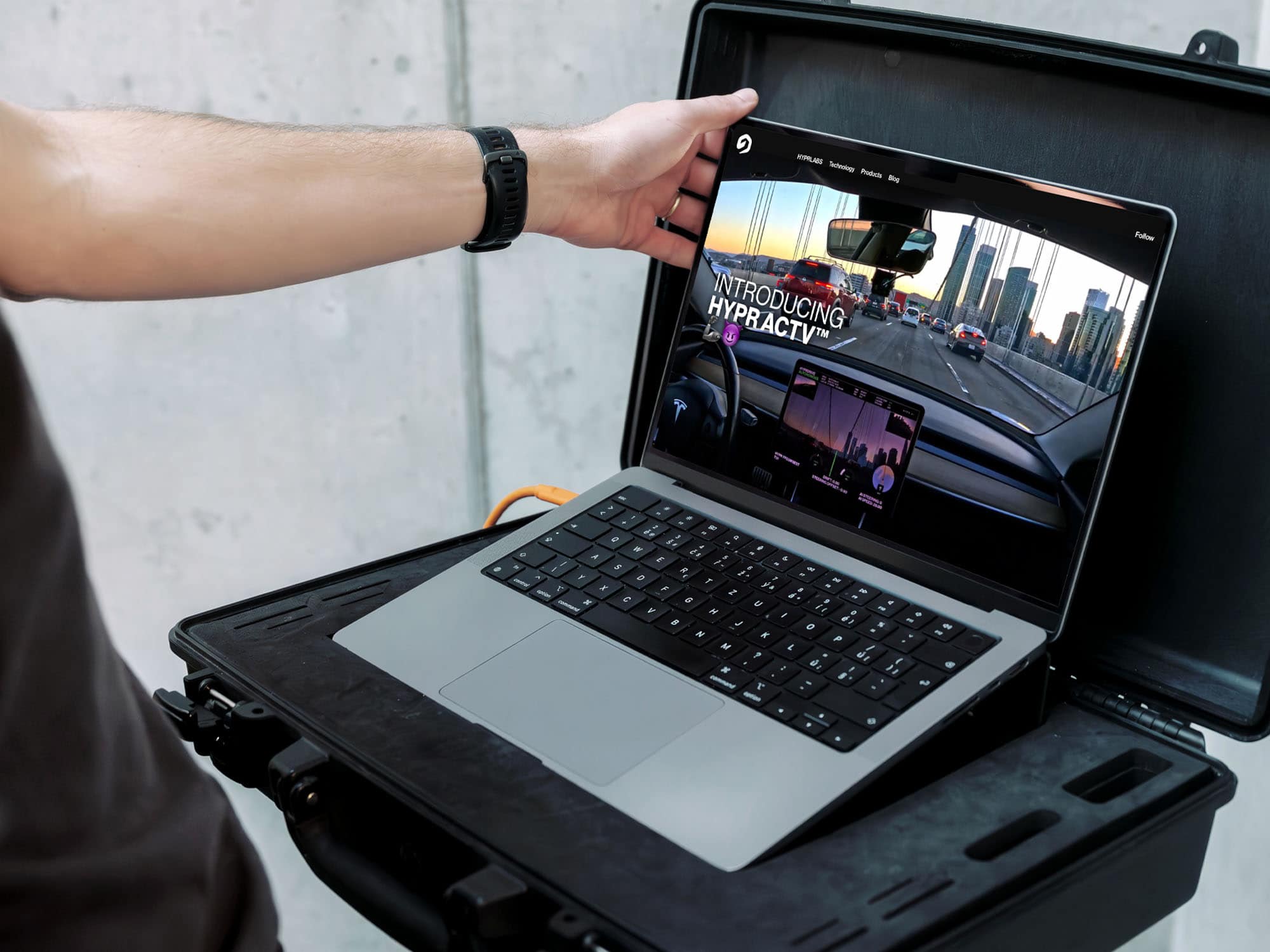 A Person Holds A Black Case With An Open Laptop Inside, Displaying A Website Featuring A Car Dashboard View And City Skyline, With The Text “Introducing Hyparcity.”.
