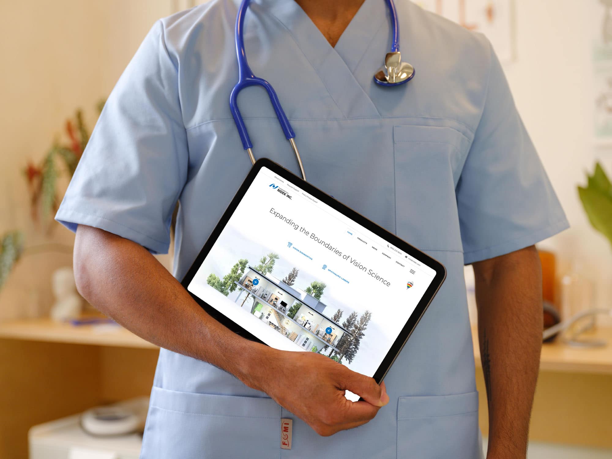 A Person In Scrubs With A Stethoscope Holds A Tablet Displaying A Website With A Building And Trees On The Screen. The Background Includes Medical Office Elements And Plants.